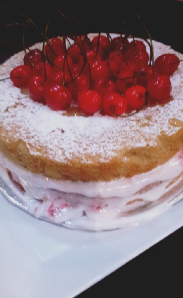4.Place the second cake on top and sprinkle caster sugar and cherries.